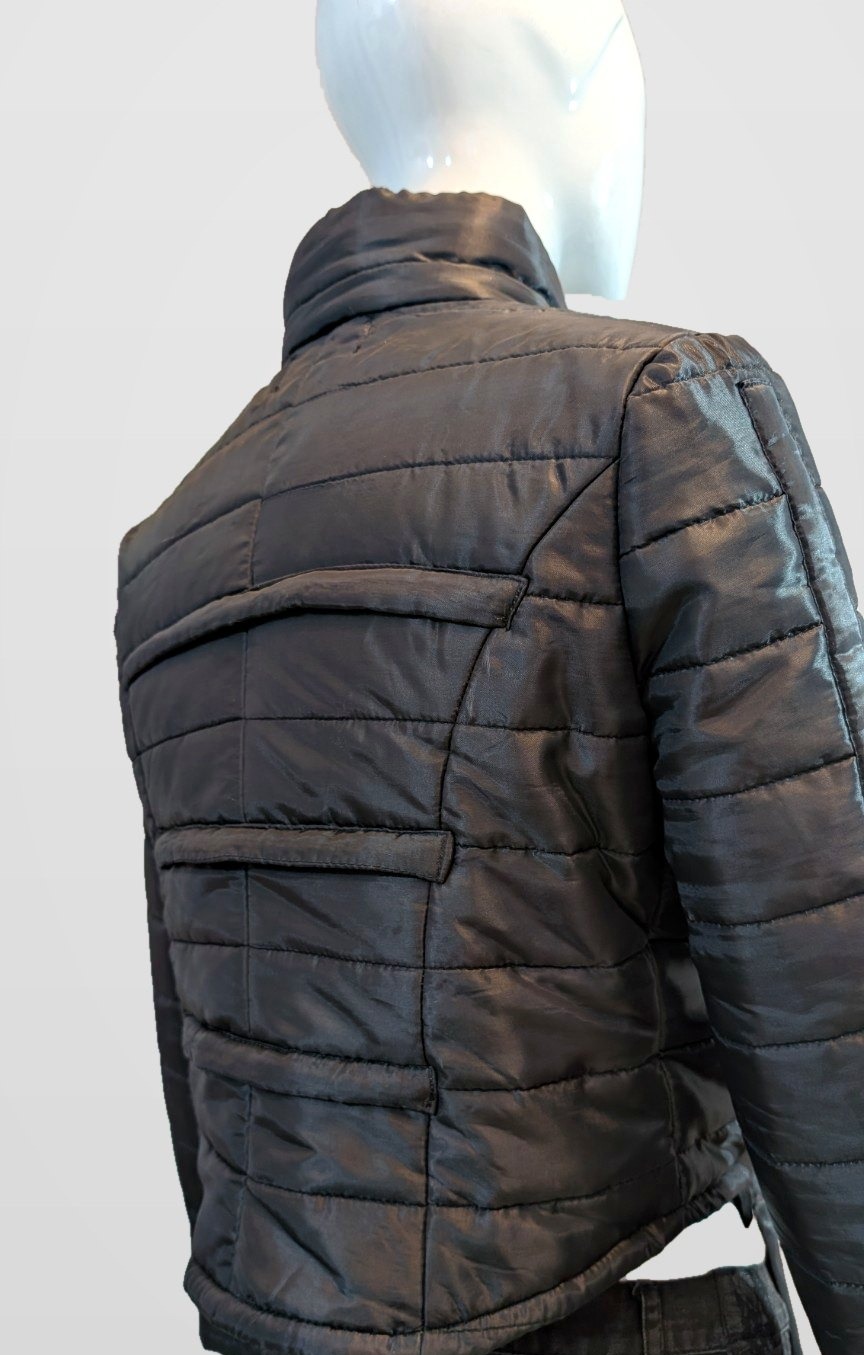 Black Nova Puffer back view showing quilted panels on a mannequin, framed just below the jacket hem