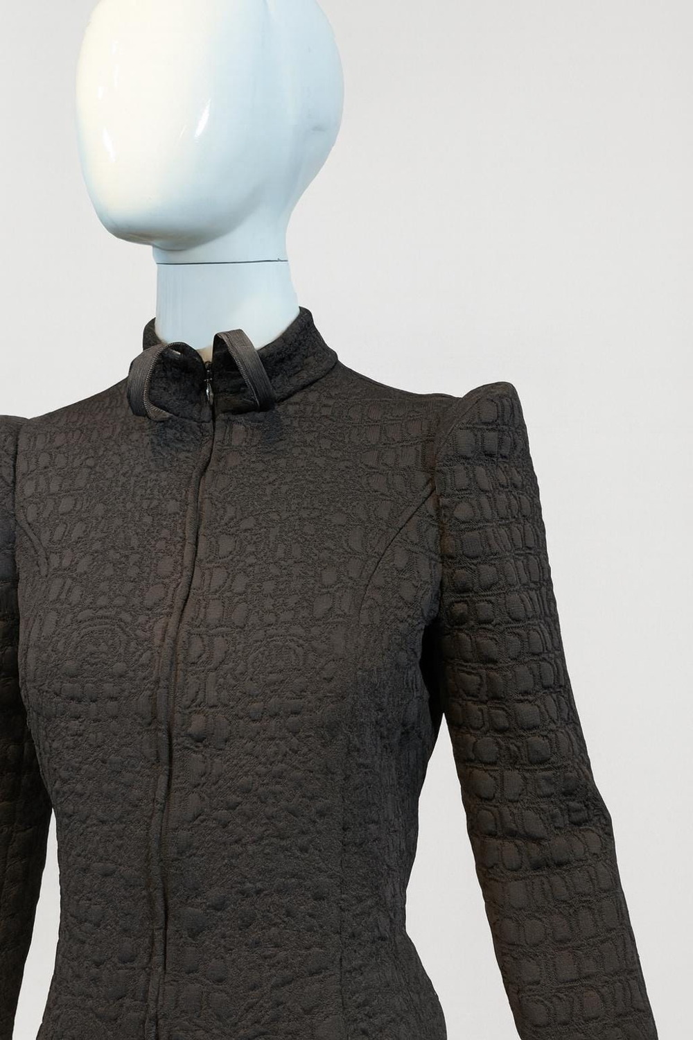 Urban Aegis Jacket — close view of black textured fabric, high collar and sculpted shoulder on a mannequin