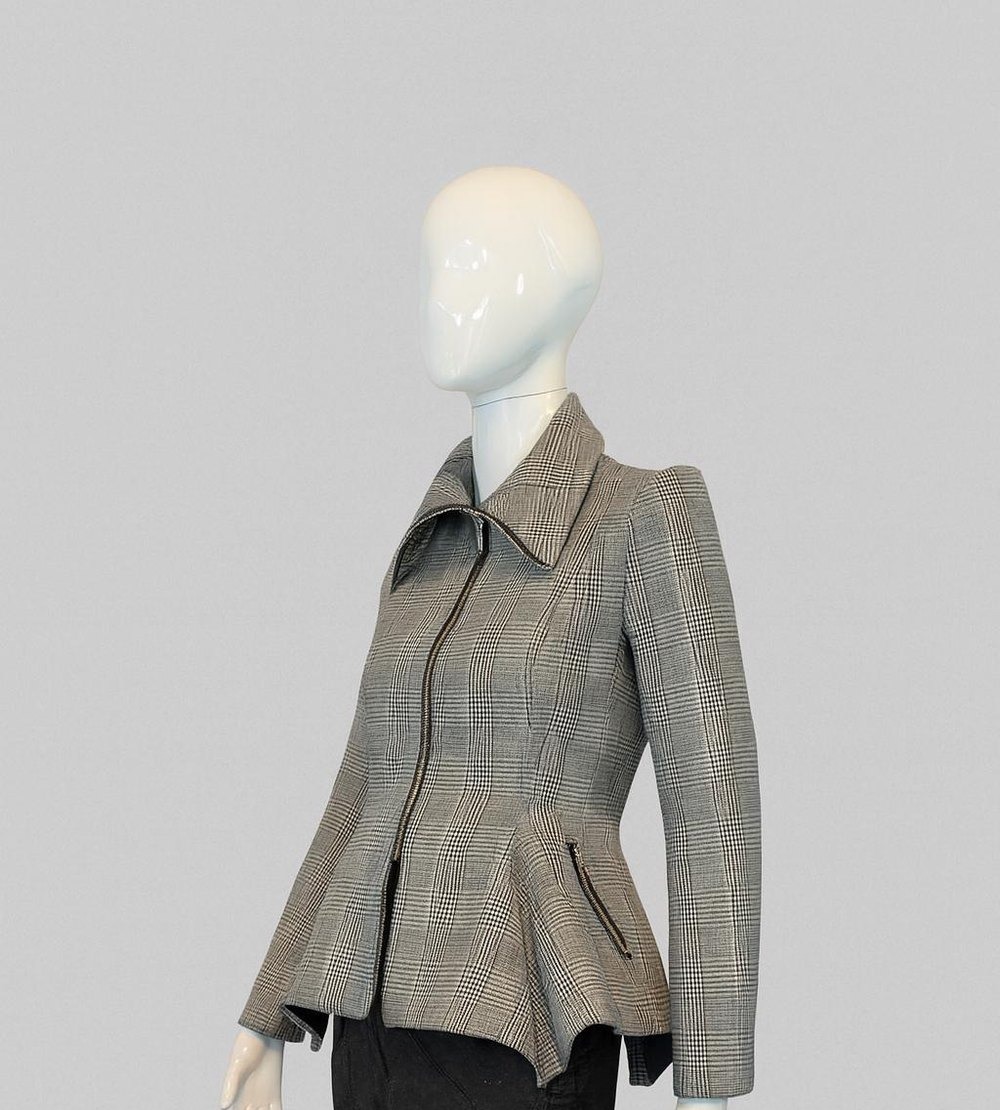 Obsidian Peplum Jacket — black and white futuristic peplum jacket on a mannequin, framed just below the peplum hem